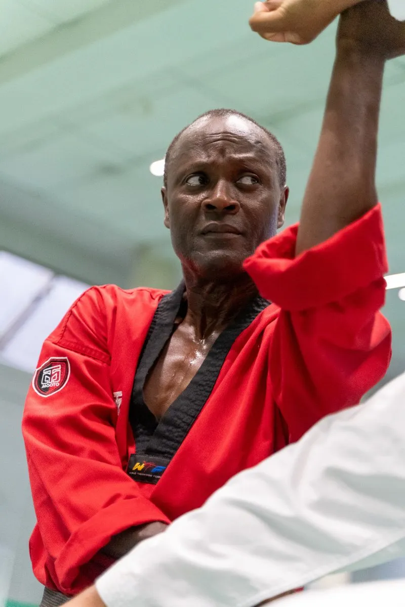 Nadjib Agbanrin, directeur technique, en dobok rouge, bras levé en blocage haut