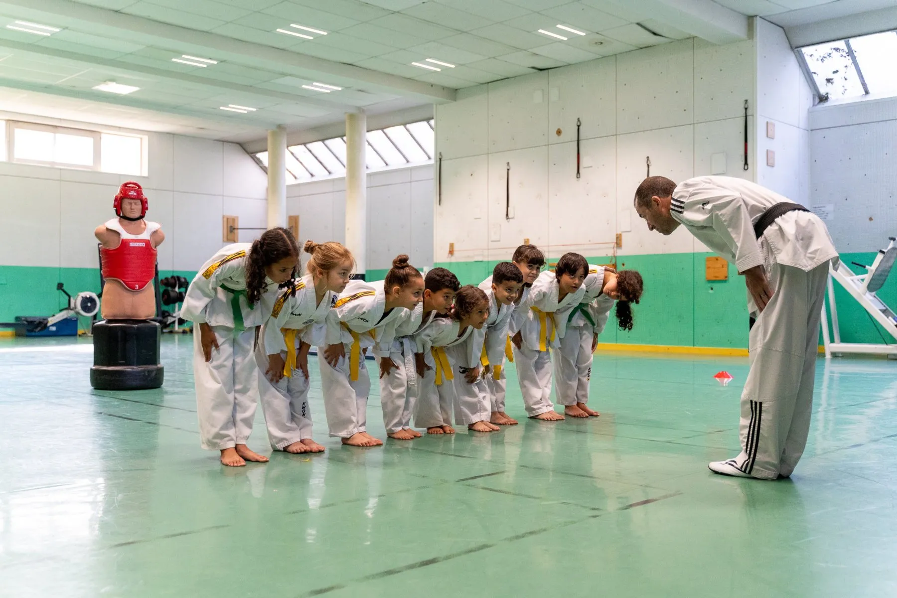 Un groupe d'enfants s'incline pour saluer l'instructeur en début de cours